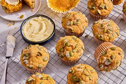 Easy Pumpkin Muffins on a cooling rack with a dish of butter - select to zoom