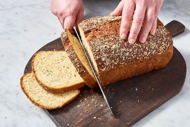 Slicing a loaf of Multigrain Protein Bread.