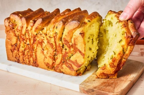 A slice of Jalapeño-Cheddar Pull-Apart Bread being pulled from the loaf
