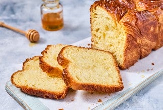 Loaf of Laminated Challah sliced on a cutting board