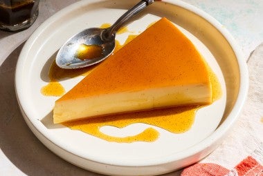 A slice of flan on a white plate.