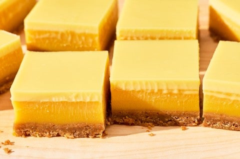 Passionfruit Bars - angled side view - layers of yellow passionfruit curd, crust, and cream.