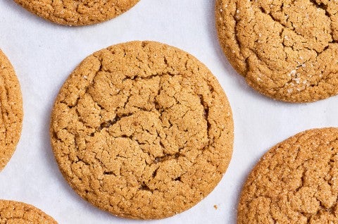 Soft Brown Sugar Cookies laid out on white parchment showing the top of the cookies with a soft cracked top and dark golden hues. - select to zoom