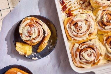 A Sweet Potato Cinnamon Roll on a plate; a bunch in a casserole dish