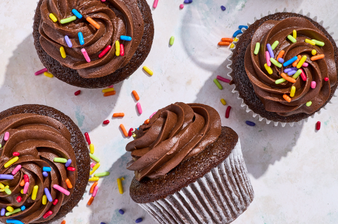 Small-Batch Chocolate Cupcakes casually arranged on a counter with sprinkles dotted about. - select to zoom
